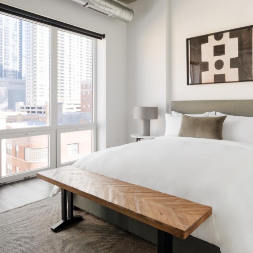 a bedroom with a bed and a large window