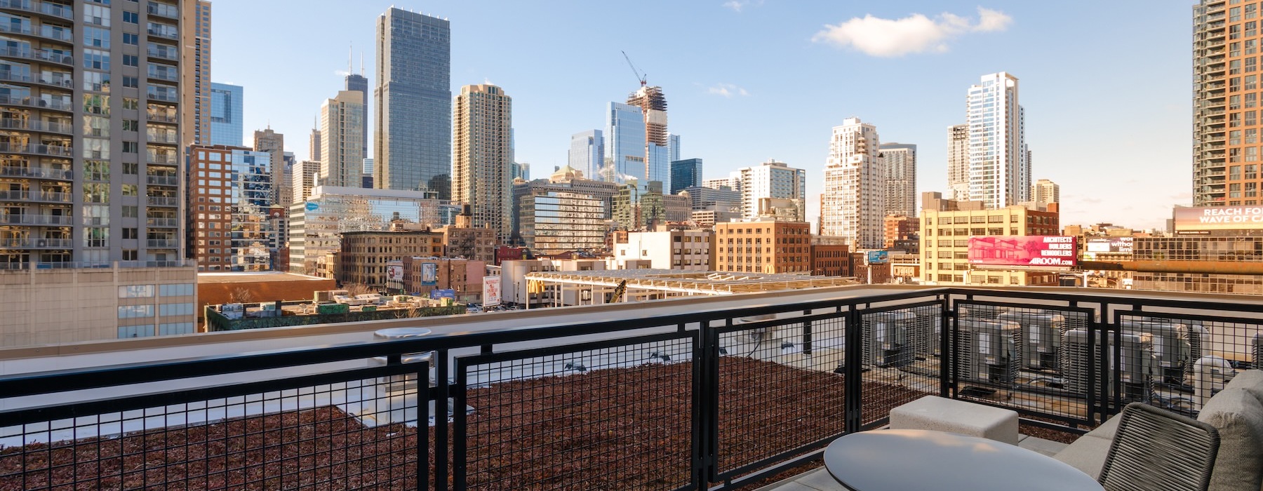 a deck with a table and chairs overlooking a city