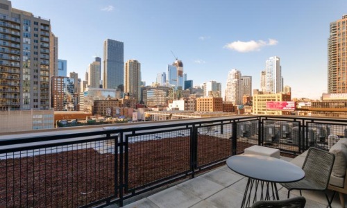 a deck with a table and chairs overlooking a city